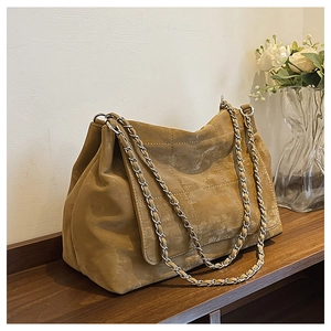 Détail du sac fourre-tout matelassé jaune moutarde avec texture daim et chaîne