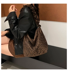 Detailed view of leopard print shoulder bag with stylish ruched handle and suede texture