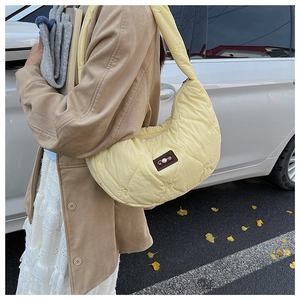 Détail du sac matelassé jaune clair avec broderie cœur et patch en cuir décoratif
