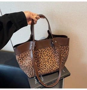 Gros plan du sac cabas léopard avec bordures en cuir marron et rivets argentés