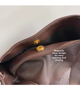 Détail d'un sac seau en cuir marron montrant le fermoir magnétique doré sécurisé