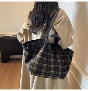 Detail of checkered nylon tote bag with black leather straps and silver metal studs