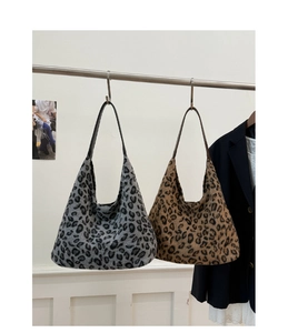 Détail de grands sacs cabas en peluche léopard gris et marron avec fines anses en cuir noir
