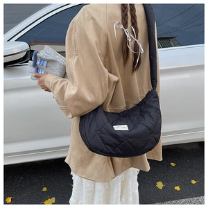 Détail du sac croissant noir matelassé avec coutures en cœur et bandoulière large