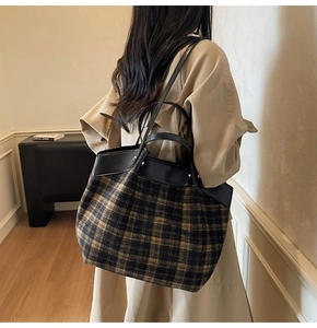Gros plan du sac cabas à carreaux en tissu avec des finitions en cuir noir élégantes