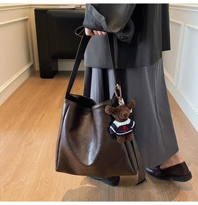 Sac cabas en cuir souple marron avec pendentif ours en peluche porté par un mannequin