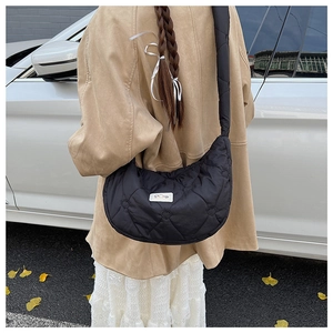 Détail du sac à bandoulière noir en forme de croissant avec matelassage en cœur chic