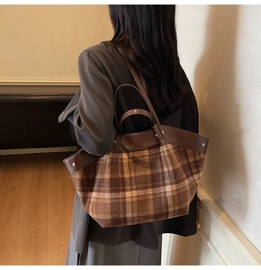 Détail du tissu à carreaux marron et de la bandoulière en cuir de ce grand sac cabas