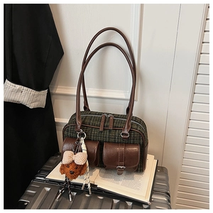 Détail du sac polochon vintage à carreaux avec breloque ours et poches magnétiques