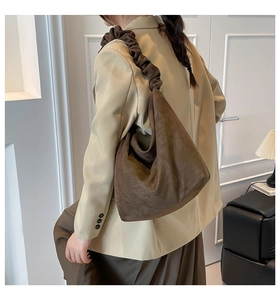 Detail of deep brown suede hobo bag featuring a unique minimalist scrunchie shoulder strap