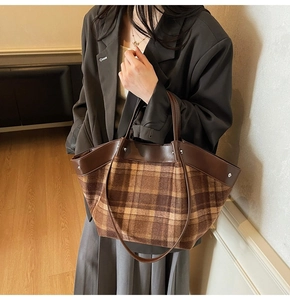 Détail d'un sac cabas à carreaux vintage avec anses en cuir et bandoulière réglable