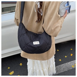 Détail du sac lune en nylon matelassé noir avec broderie cœur et étiquette de marque