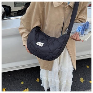 Détail du sac croissant en nylon noir avec surpiqûres cœurs et étiquette de marque