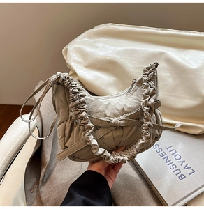 Vue détaillée du sac croissant plissé kaki avec nœud décoratif et poignée froncée