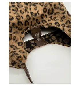 Détail du fermoir magnétique d'un sac cabas en peluche léopard avec bordure en cuir
