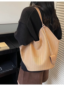 Brown woven tote bag with large capacity and matching small pouch shown on model