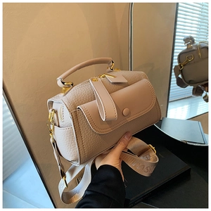Dettaglio della borsa beige in pelle martellata con finiture dorate e tracolla larga