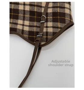 Detail of adjustable leather strap and plaid fabric on leopard tote bag with silver buckle