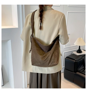 Detail of deep brown suede Hobo bag showing the wide shoulder strap and drawstring knot