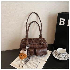 Détail du sac vintage pied-de-poule marron avec poches en cuir et breloque chien