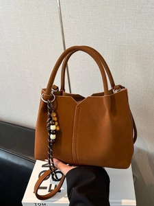 Brown frosted tote bag with wooden bead charm and detachable shoulder strap in a stylish view