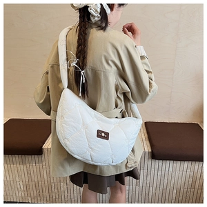 Détail du sac à bandoulière blanc en demi-lune avec surpiqûres matelassées en cœur