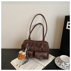 Détail du sac rétro à carreaux avec poches en cuir et pendentif ours en peluche