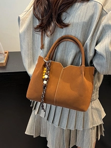 Caramel brown suede bucket bag with beaded tassel and V-cut detail for women