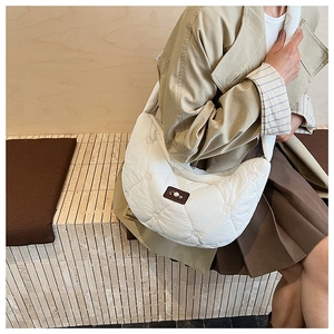 Vue détaillée du sac croissant blanc avec surpiqûres cœurs et patch de marque