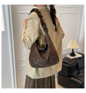 Detail of leopard print tote bag featuring a stylish scrunchie shoulder strap design