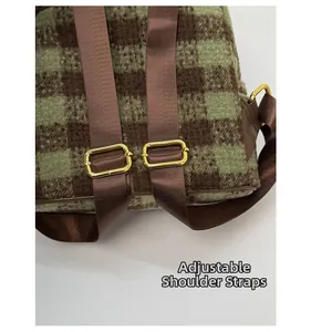 Detail of adjustable nylon shoulder straps with golden metal buckles on plaid backpack