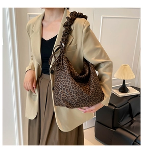 Detail of trendy leopard print tote bag with stylish scrunchie shoulder strap design