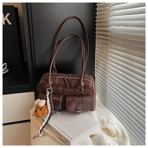 Détail du sac à motif pied-de-poule marron avec breloque ours en peluche et ruban