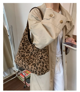 Détail du sac hobo en peluche léopard avec bandoulière en cuir porté par un mannequin