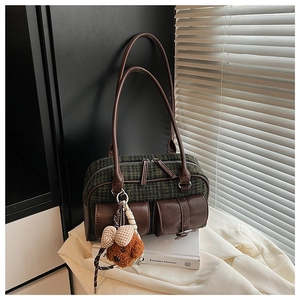 Détail du sac vintage en tweed à carreaux avec garniture en cuir brun et breloque ours