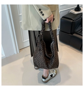 Detailed close-up of leopard print tote bag with pleated handle and soft canvas texture