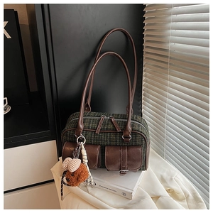 Détail du sac polochon vintage à carreaux verts avec poches et pendentif ours mignon
