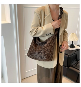Detail of the leopard print tote bag with wide shoulder strap worn by a model