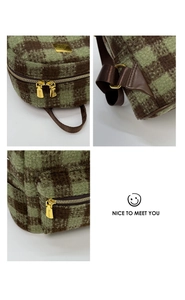 Detail of green checkerboard tweed backpack with gold dual zippers and woven strap