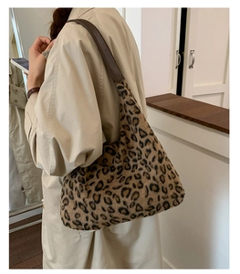 Détail du sac bandoulière en peluche léopard avec bandoulière en cuir porté par un mannequin