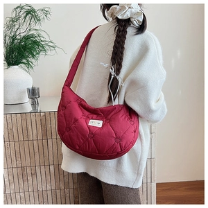 Détail du sac bandoulière bordeaux matelassé en cœurs avec tissu en nylon et sangle