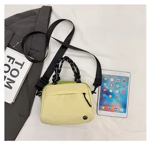 Detail view of contrast nylon crossbody bag with woven handle and adjustable strap