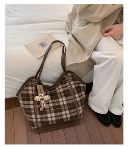 Close-up of a large plaid tote bag in brown and beige with a cute rabbit keychain accessory