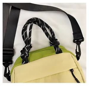 Detail of color-block nylon handbag with woven rope handle and adjustable shoulder strap