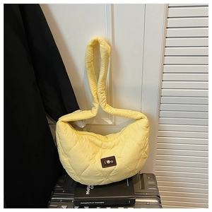 Détail du matelassage en cœur et étiquette perle sur sac banane jaune clair
