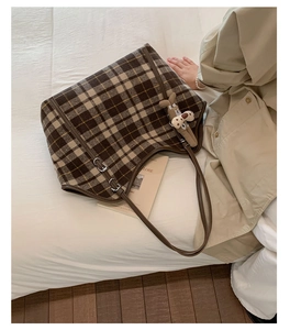Brown plaid wool tote bag detail with leather straps and a cute puppy plush charm