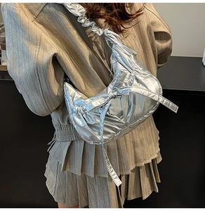 Détail d'un sac bouffant argenté métallisé avec nœud et bandoulière froncée stylée