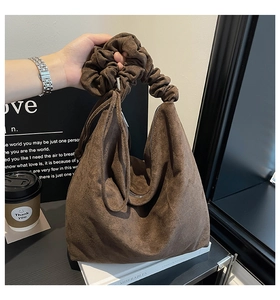 Detail of deep brown suede tote with stylish ruched handle and side drawstring
