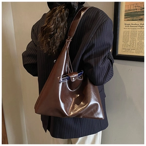 Detailed side view of large brown faux leather tote bag with functional side pocket