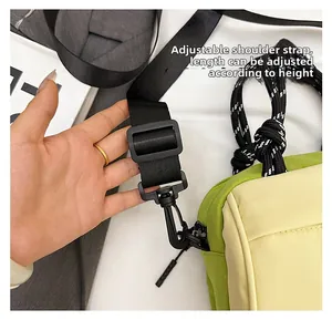 Detail of adjustable black nylon shoulder strap on the bicolor crossbody messenger bag